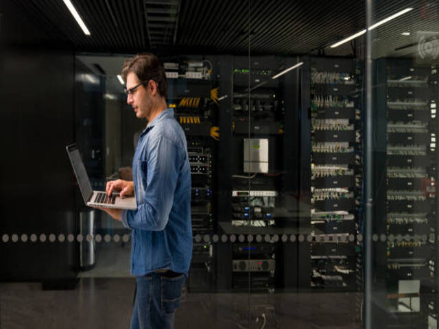IT technician fixing a problem on a network server at an office building â technology concepts