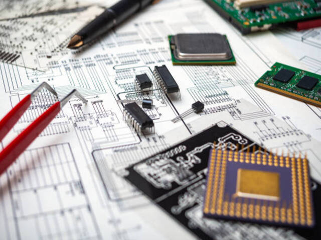Electronic components and tools on an engineering blueprint for circuit board design.